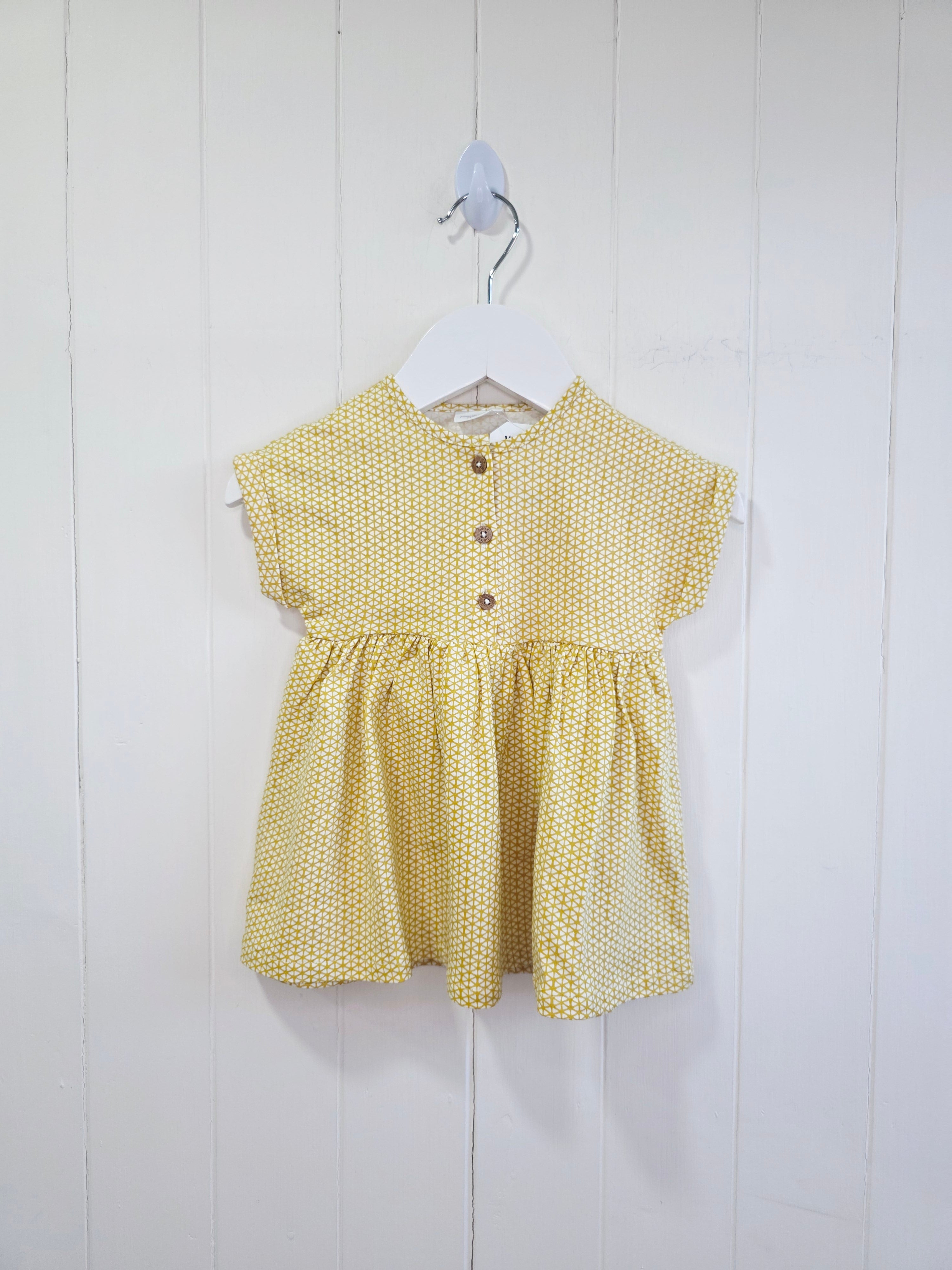 Next - up to 3 months baby dress features a mustard yellow geometric print