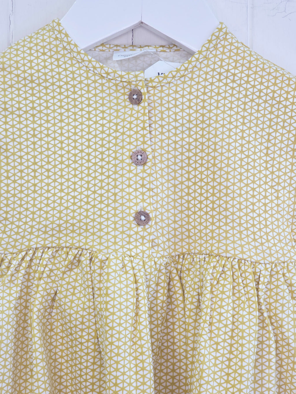 Next - up to 3 months baby dress features a mustard yellow geometric print