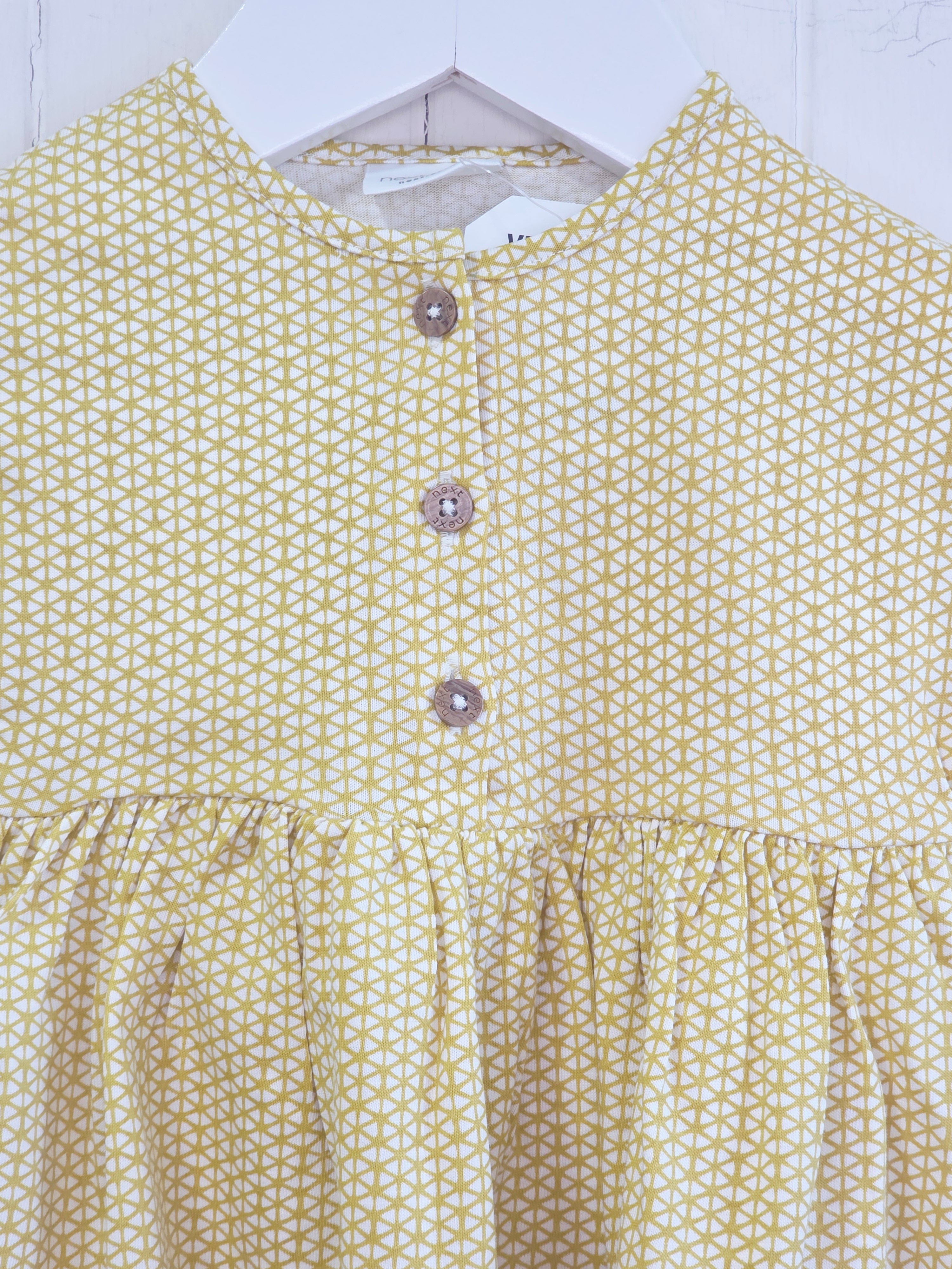 Next - up to 3 months baby dress features a mustard yellow geometric print