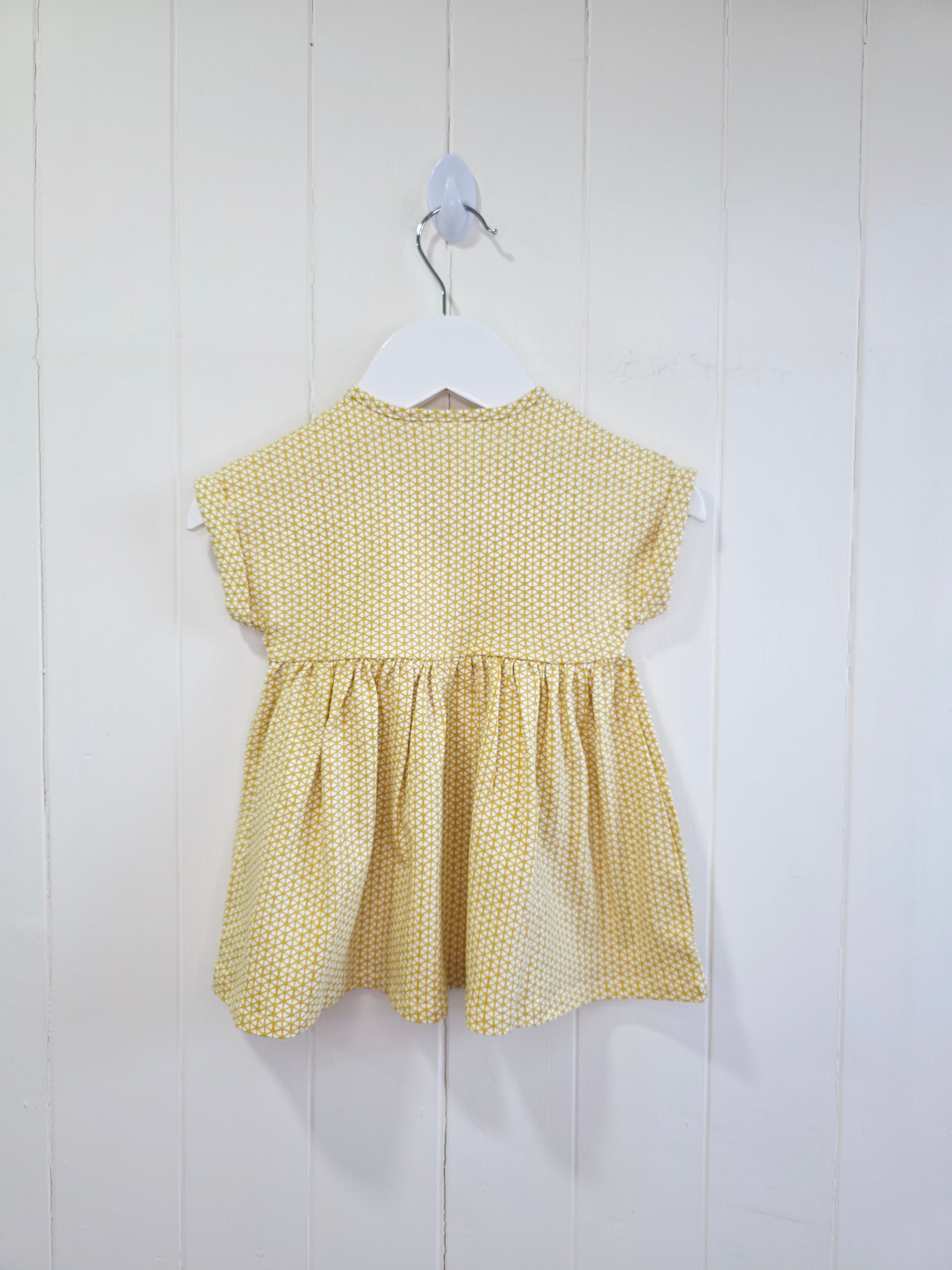 Next - up to 3 months baby dress features a mustard yellow geometric print