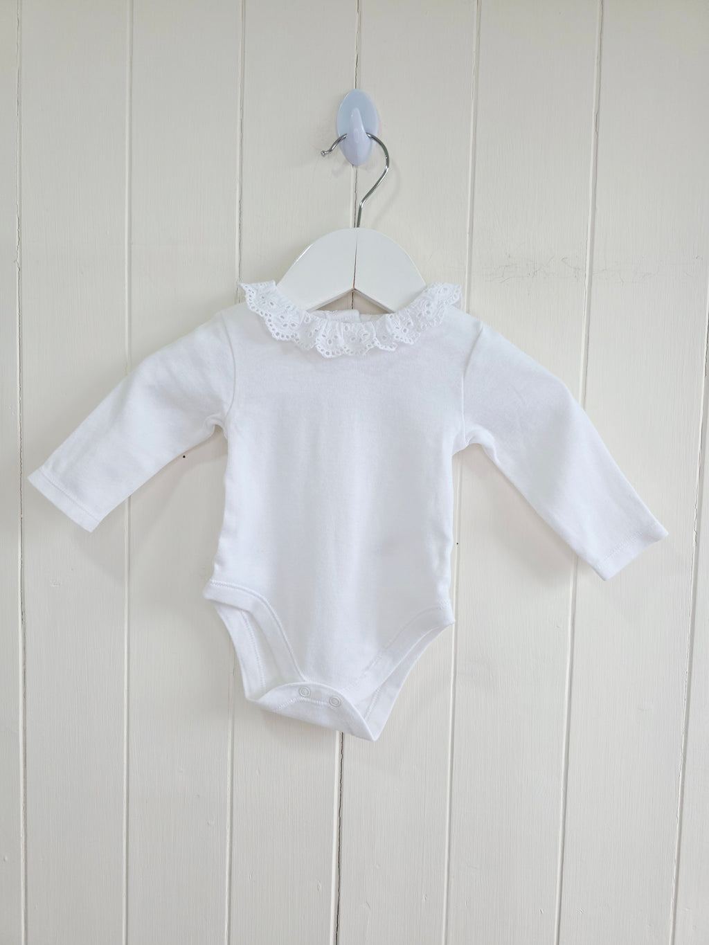 Nutmeg - 0-3 months girls bodysuit features a delicate white embroidered frill collar and long sleeves