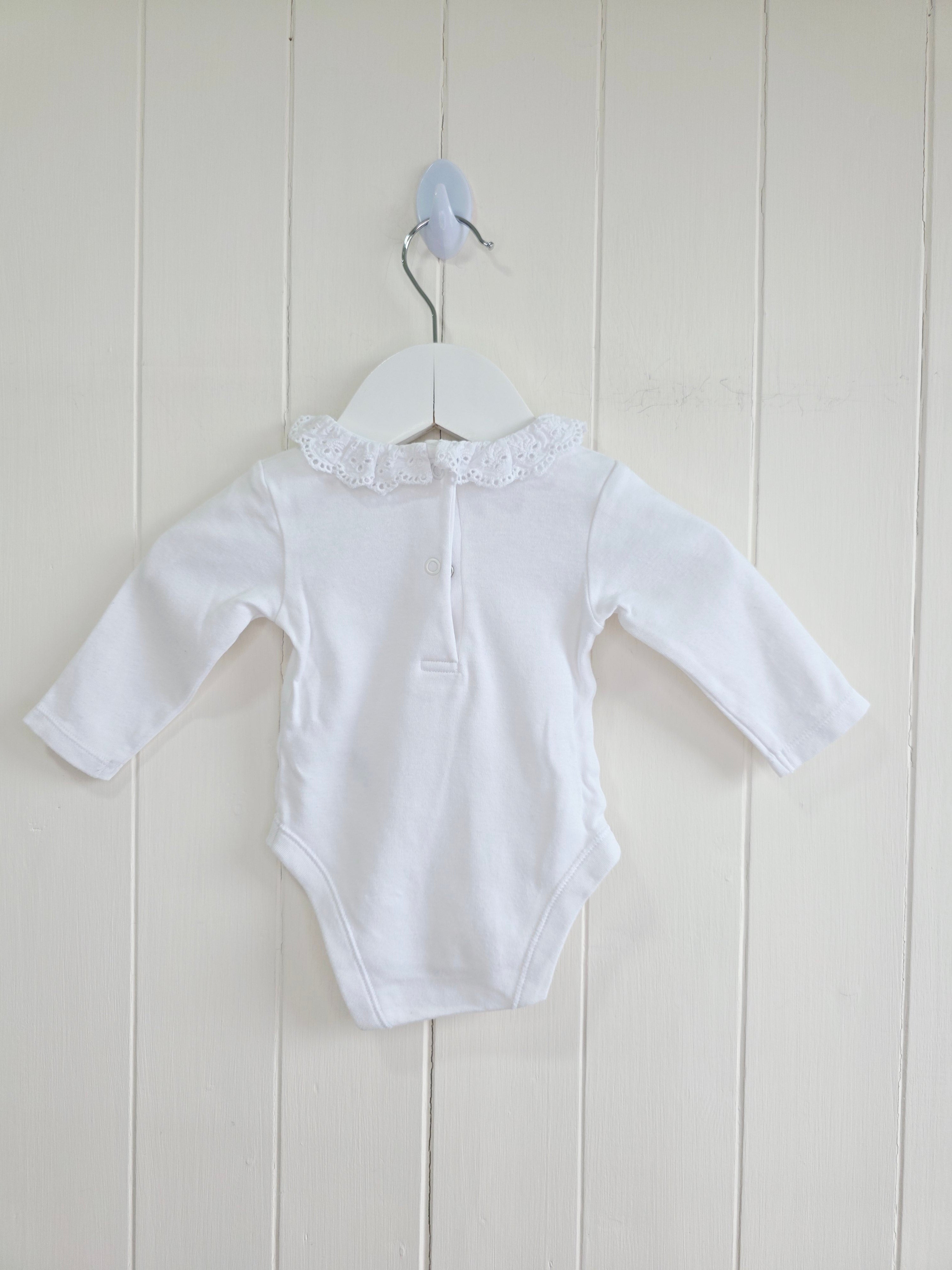Nutmeg - 0-3 months girls bodysuit features a delicate white embroidered frill collar and long sleeves