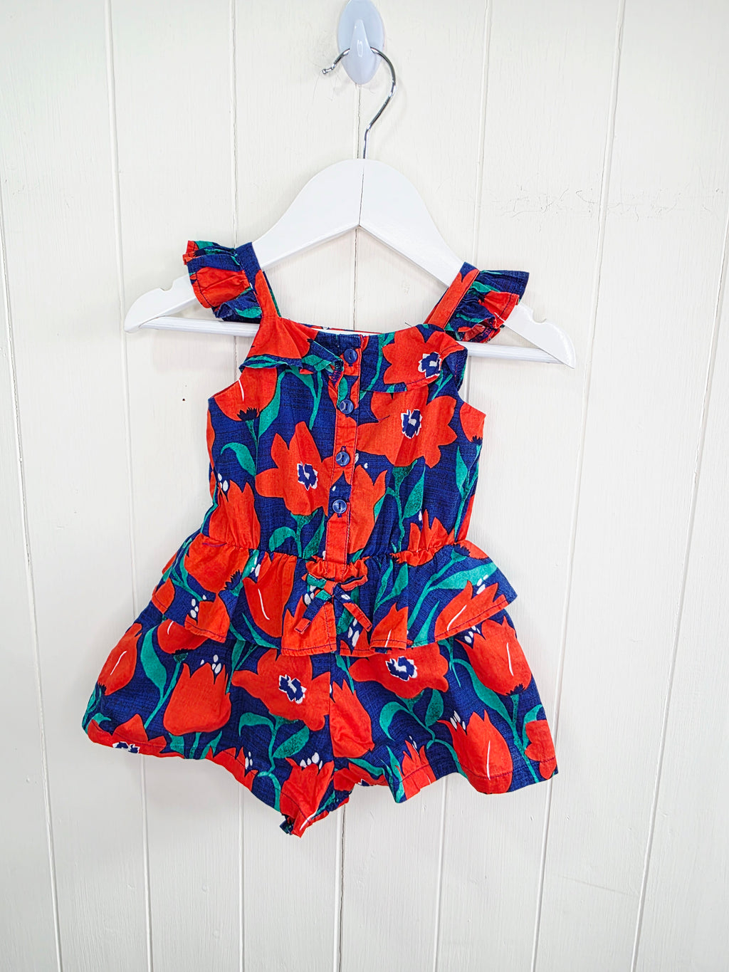 Next 3-6 months floral-print baby romper features a vibrant red and blue color scheme with ruffled straps