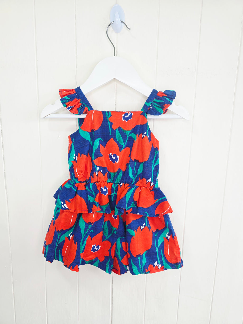 Next 3-6 months floral-print baby romper features a vibrant red and blue color scheme with ruffled straps