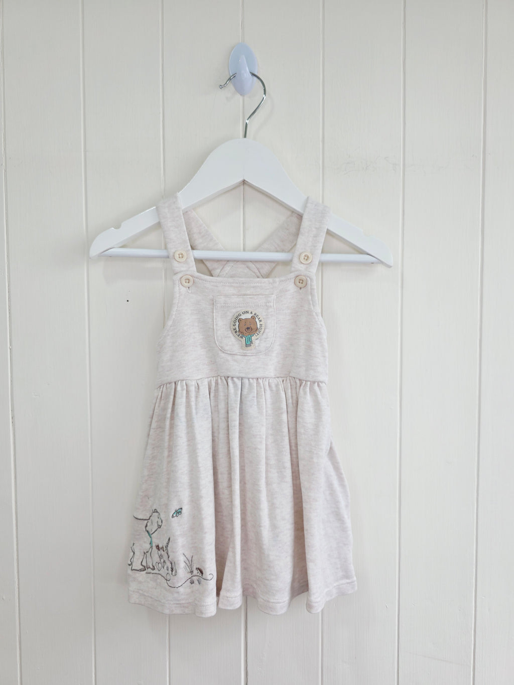 3-3 months pinafore dress features an embroidered "We're Going on a Bear Hunt" design and charming button details