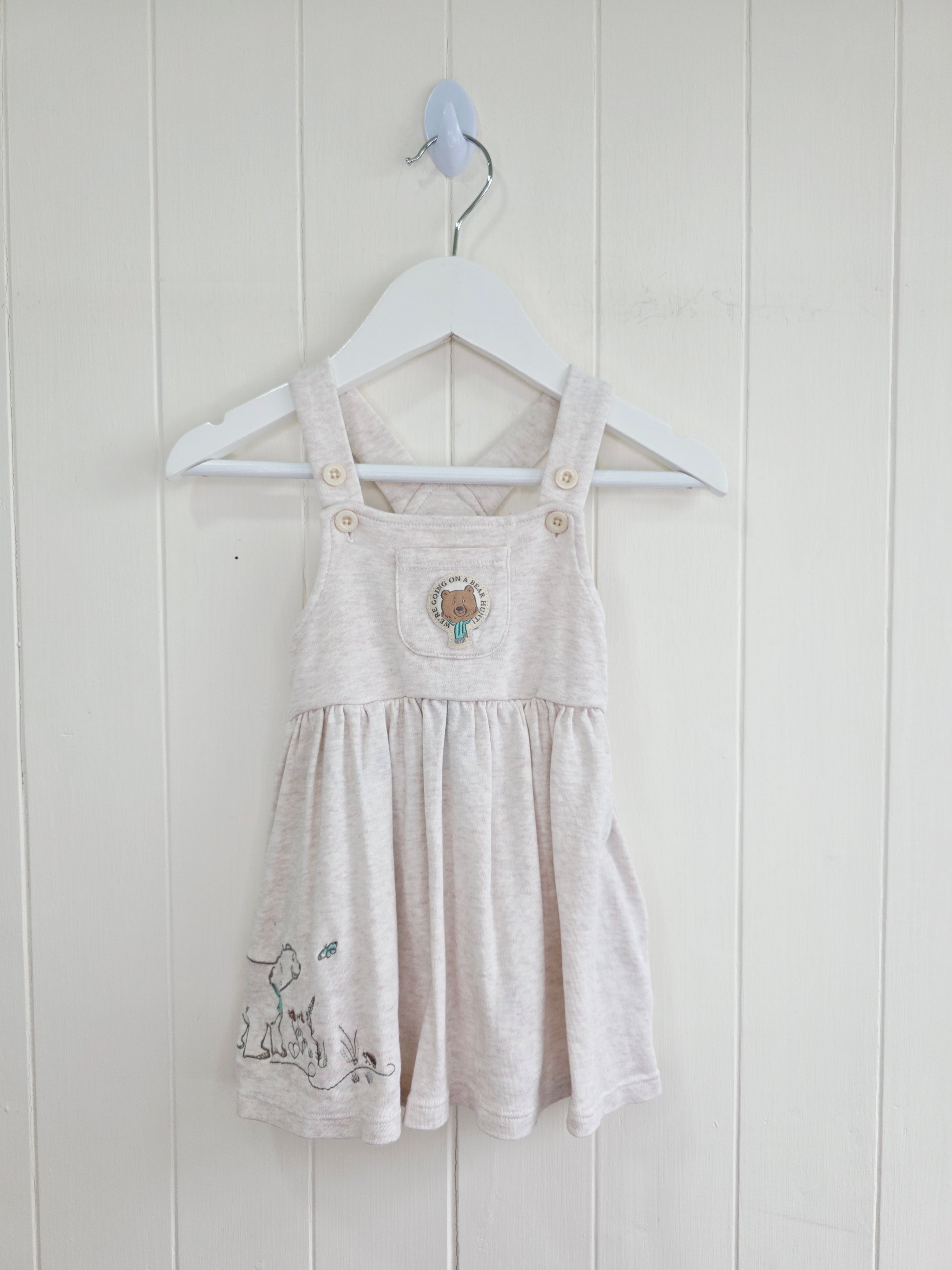 3-3 months pinafore dress features an embroidered "We're Going on a Bear Hunt" design and charming button details