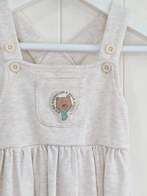 3-3 months pinafore dress features an embroidered "We're Going on a Bear Hunt" design and charming button details