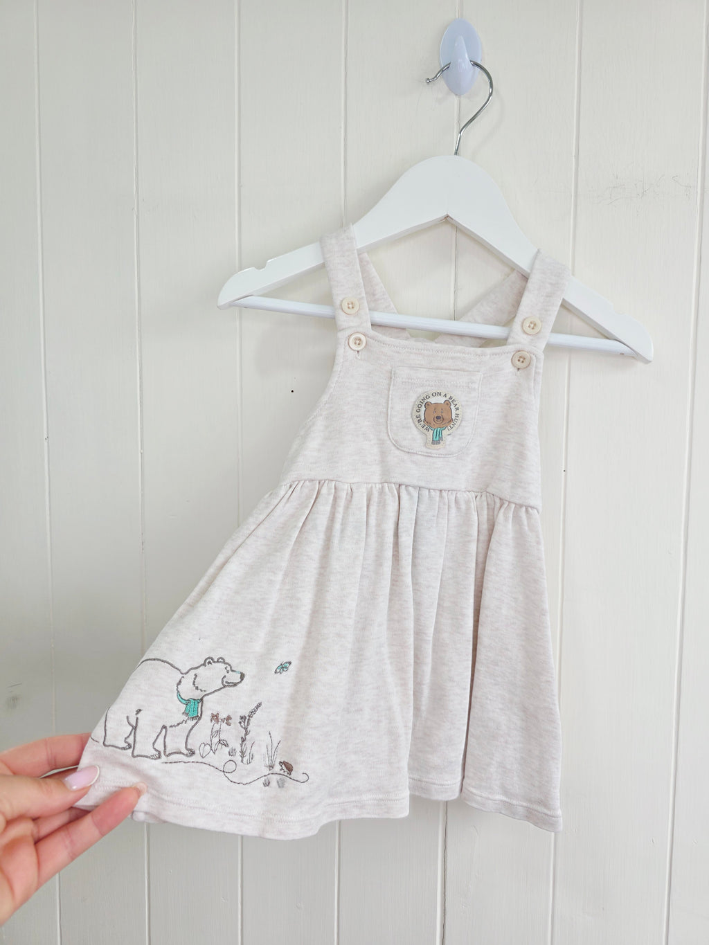 3-3 months pinafore dress features an embroidered "We're Going on a Bear Hunt" design and charming button details